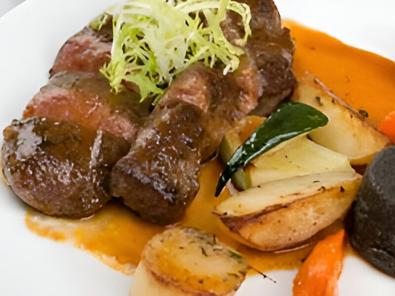 Plato de carne al horno con papas a la española doradas y cebolla