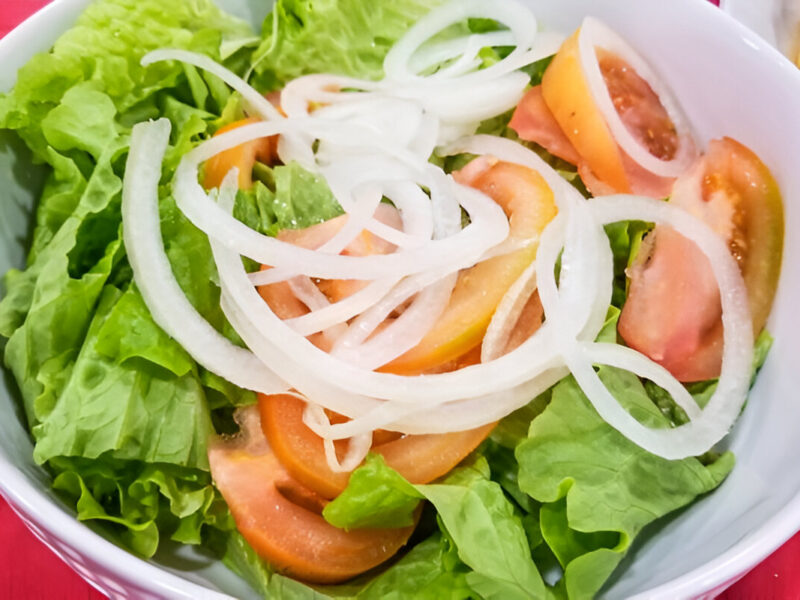 Plato de ensalada mixta con lechuga, tomate, cebolla y zanahoria rallada