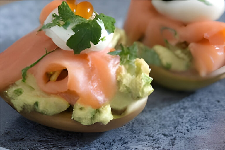 Huevos rellenos decorados con salmón ahumado, palta y perejil fresco.
