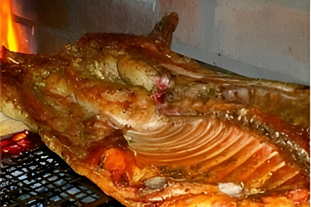 Lechón a la parrilla dorado y crujiente cocinado a fuego lento sobre brasas