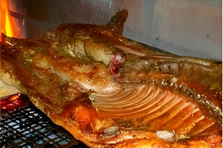 Lechón a la parrilla dorado y crujiente cocinado a fuego lento sobre brasas