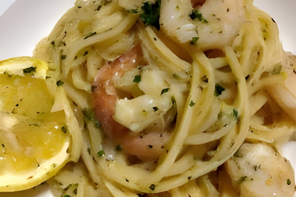 Pasta con camarones salteados al ajo en manteca de limón, servida con perejil fresco y ralladura de limón