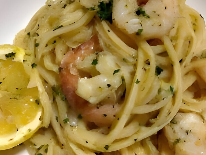 Pasta con camarones salteados al ajo en manteca de limón, servida con perejil fresco y ralladura de limón