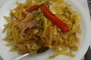 Revuelto Gramajo casero con papas fritas, jamón y huevo, servido caliente