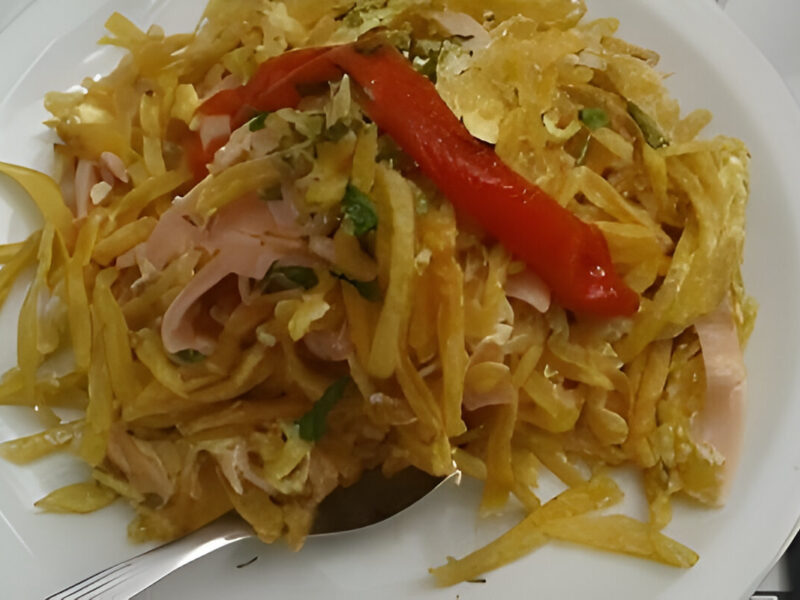 Revuelto Gramajo casero con papas fritas, jamón y huevo, servido caliente