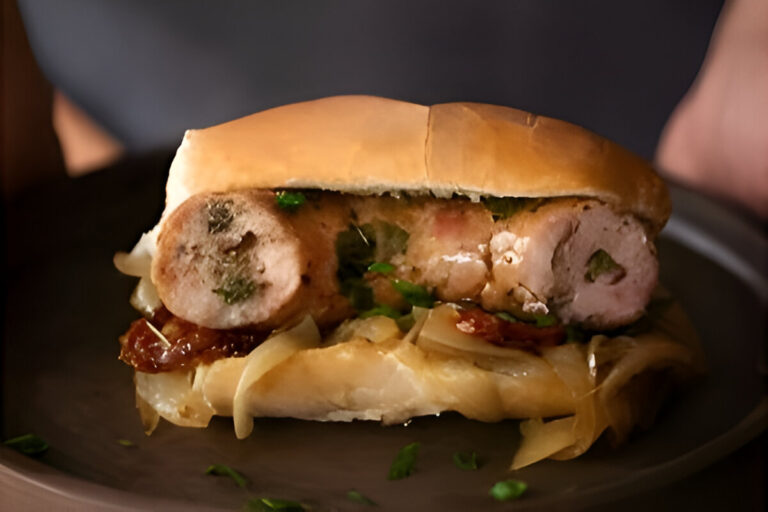 Choripán argentino con chimichurri servido en pan casero, acompañado de papas fritas y una bebida fría