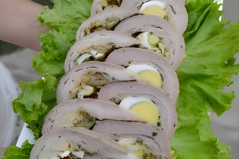 Matambre arrollado casero relleno con vegetales, huevo y especias, servido en rodajas sobre una tabla de madera