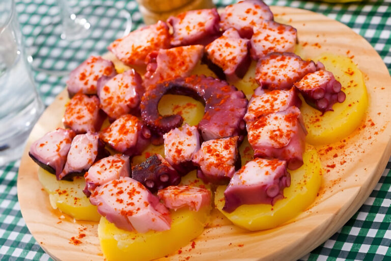 Pulpo a la gallega servido sobre papas y pimentón