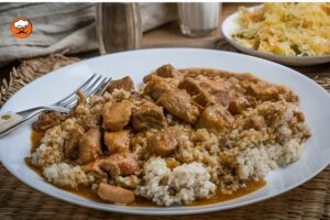 Sémola de cebada con carne guisada servida en plato hondo