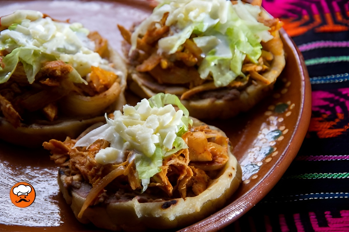 Sopes de tinga mexicanos con pollo, frijoles y queso fresco