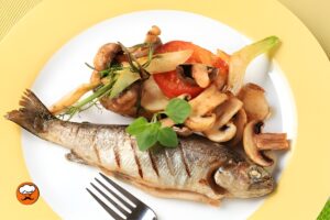 Trucha frita crujiente acompañada de verduras salteadas y hierbas frescas