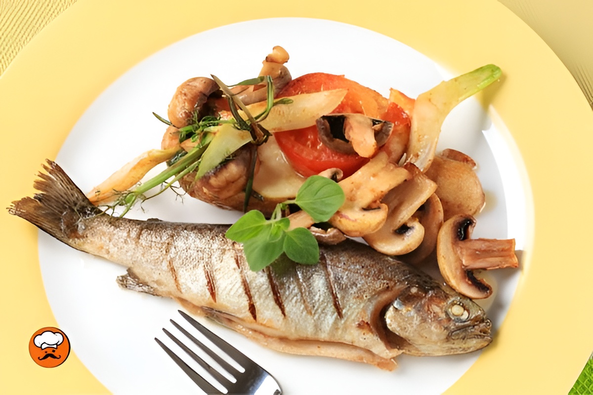 Trucha frita crujiente acompañada de verduras salteadas y hierbas frescas