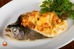Trucha rellena al horno con camarones, queso fundido y hierbas frescas