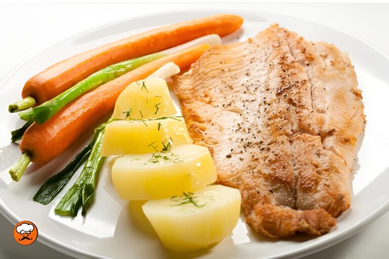 Trucha frita crujiente acompañada de papas, zanahorias y cebolla de verdeo al vapor