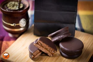 Alfajores de dulce de leche y chocolate sobre una tabla de madera