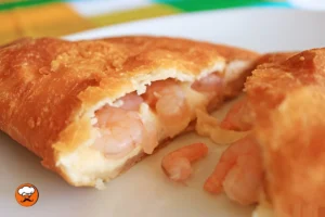 Empanadas caseras rellenas de camarones y queso fundido sobre un plato