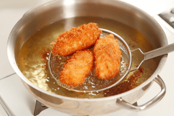 Recetas de carnes fritas con piezas empanizadas y doradas en aceite caliente.